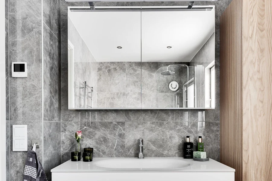 Contemporary bathroom with minimalist design featuring marble walls and sleek furniture.